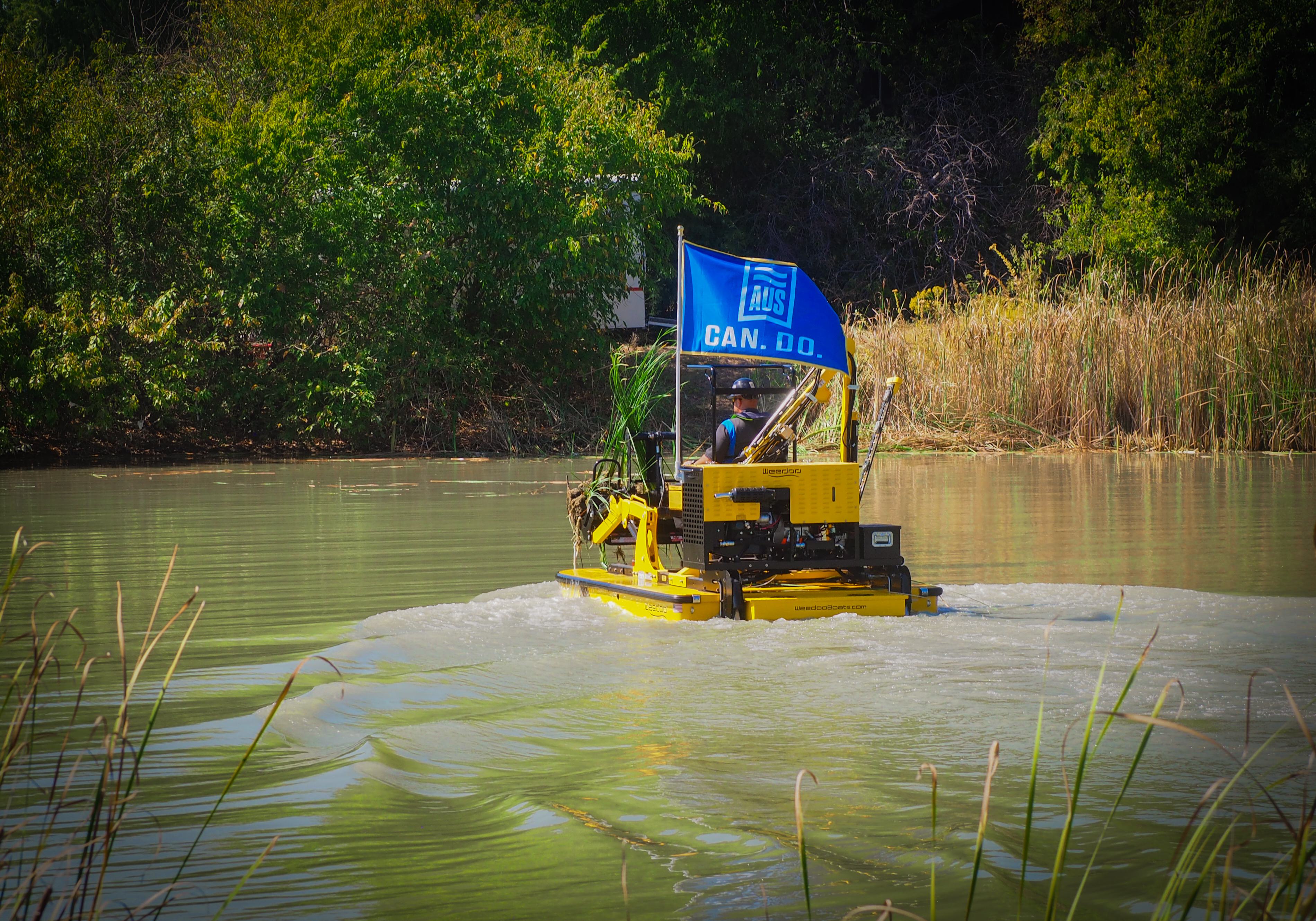 Weedoo dredging boat performing precision sediment removal in shallow pond